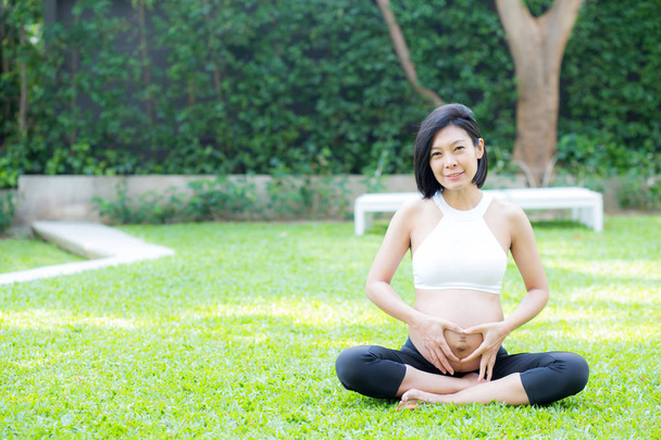 ジェスチャーハンドヒーを持つ幸せな妊娠中の美しい若いアジアの女性 - 写真・画像
