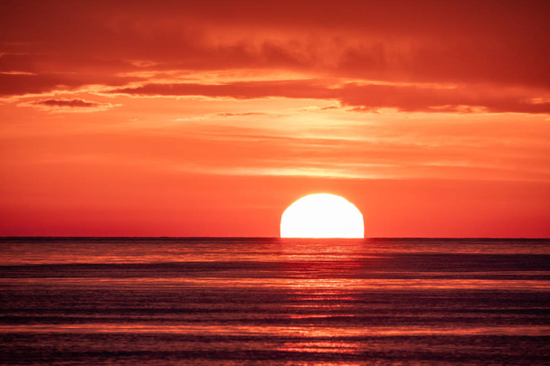 Beautiful red and orange sunset over the sea. The sun goes down over the sea. - Foto, afbeelding