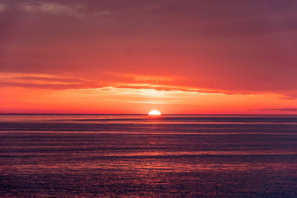 Beautiful red and orange sunset over the sea. The sun goes down over the sea. - Fotografie, Obrázek