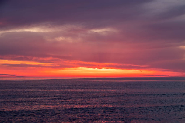 Beautiful red and orange sunset over the sea. - Фото, изображение