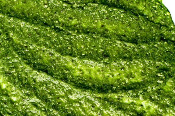 Frersh Italiaanse pesto saus verspreid groene textuur achtergrond - Foto, afbeelding