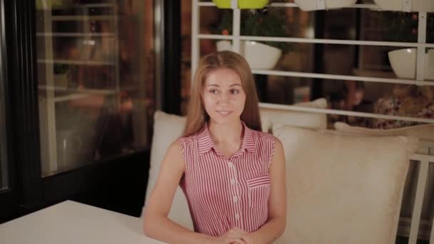Beautiful girl awaiting her order in an evening cafe. - Footage, Video