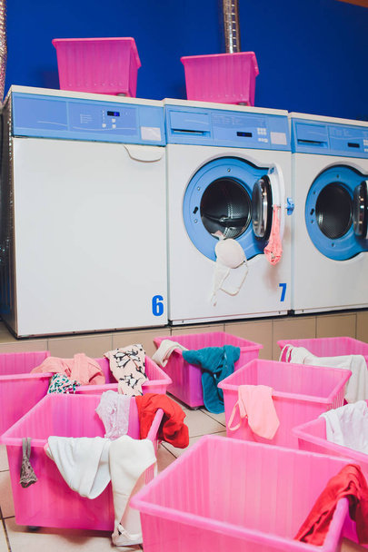woman taking color clothes from washing machine. - Foto, Bild