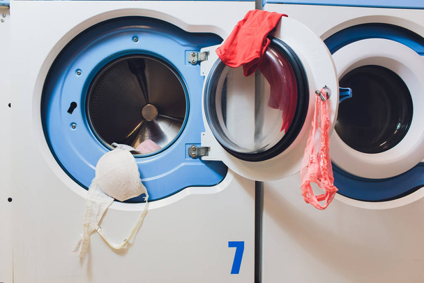 woman taking color clothes from washing machine. - Foto, immagini