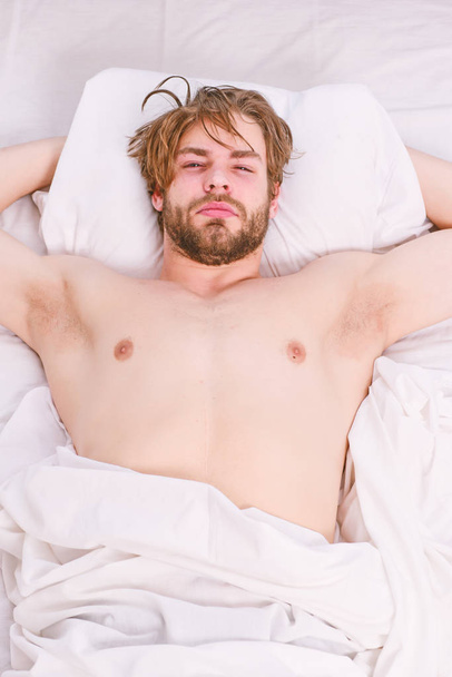 Handsome man using clock in bed after waking up in the morning. Stretch after wake up in the morning. Waking up energy. - Valokuva, kuva