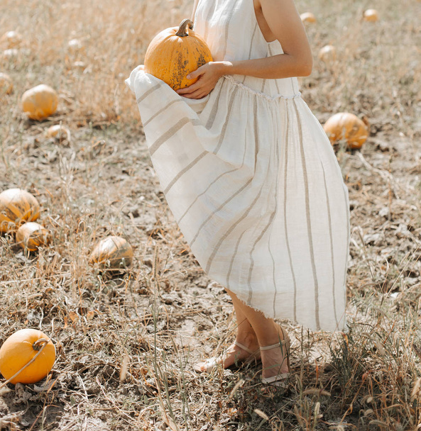 woman yellow pumpkin holds hands subject Halloween - Foto, afbeelding
