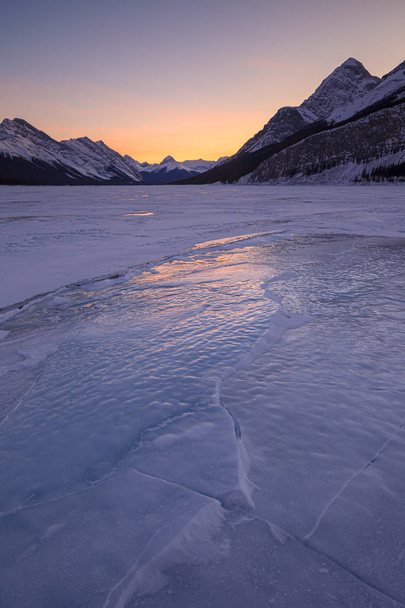 Puesta de sol en un lago congelado en Kananaskis País en las Montañas Rocosas Canadienses, Albeta
 - Foto, imagen