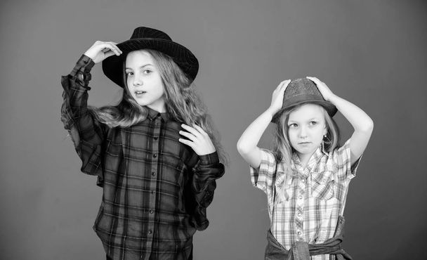 Cool cutie fashionable outfit. Happy childhood. Kids fashion concept. Check out our fashion style. Fashion trend. Girls kids wear fashionable hats. Small fashionista. Following sister in everything - Fotó, kép