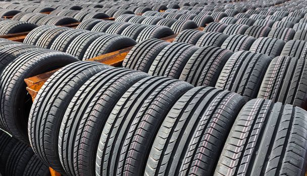 New tires for sale at a tire store. Car tires in the warehouse under the open sky - Photo, Image