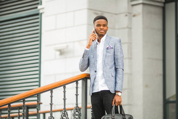 handsome young african man in a suit talking on the phone - Φωτογραφία, εικόνα