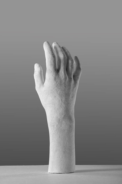 elegante mano de yeso blanco sobre un fondo gris
 - Foto, Imagen