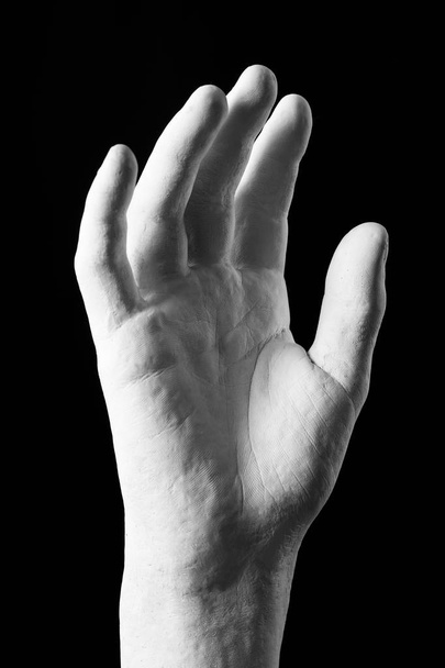 elegant white plaster hand on a black background - Foto, Bild