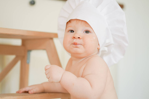 Pequeno bebê menino padeiro gostando de jogar na cozinha de perto
 - Foto, Imagem