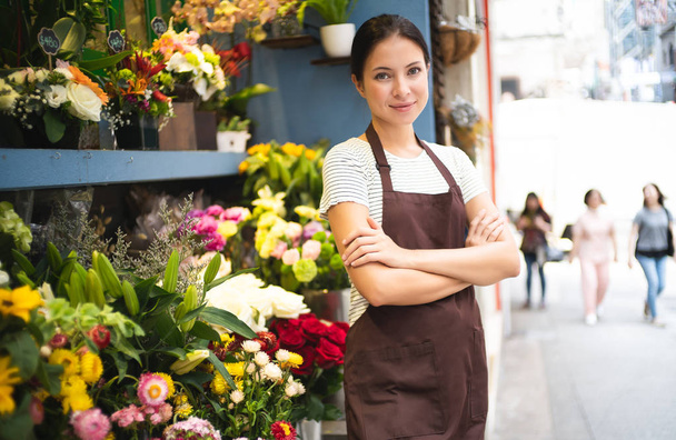 Jeune femme propriétaire d'entreprise debout à son magasin de fleurs. Jeune e
 - Photo, image
