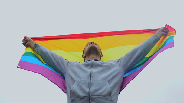 Мужчина поднимает радужный флаг, марширует за права ЛГБТ, солидарность с однополыми браками
 - Кадры, видео