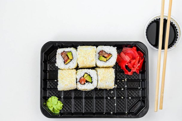 Rollos Syake en un conjunto de 6 piezas en una caja negra, con jengibre, wasabi y salsa de soja, comida rápida, orientación horizontal, vista superior
 - Foto, Imagen