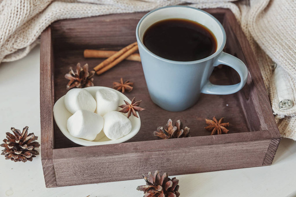 Cup of coffee on rustic wooden tray, sweet marshmallow and warm woolen sweater - Photo, Image