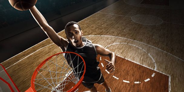 Баскетболист ныряет. Шлем-данк с высокого угла зрения с обруча
 - Фото, изображение