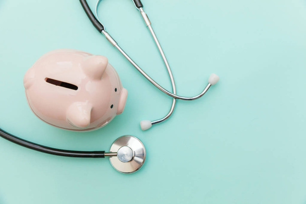 Medicine doctor equipment stethoscope or phonendoscope and piggy bank isolated on trendy pastel blue background - Foto, afbeelding
