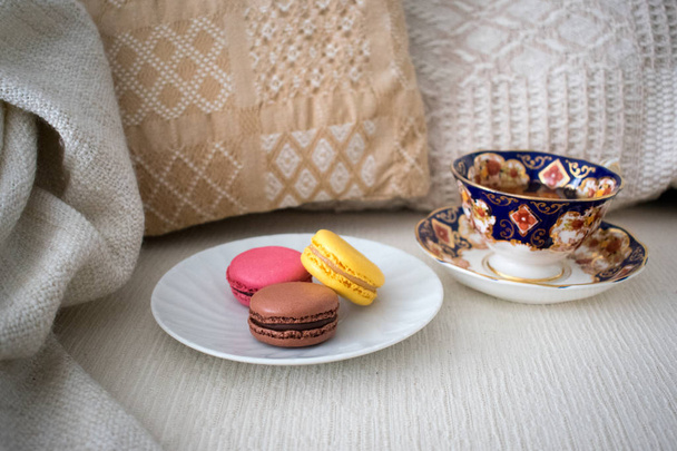 Macarons et tasse à thé dans le salon confortable
  - Photo, image