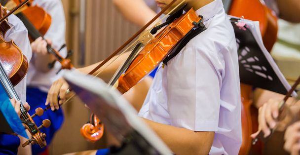 Asiático meninos estudantes tocando violino com notação de música no gro
 - Foto, Imagem