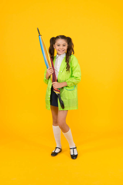 Water resistant clothes. Protected concept. Rainproof clothes. Autumn accessory. Autumn weather. Totally ready. Schoolgirl with umbrella wear waterproof raincoat. Autumn rain. Going to school - Foto, Imagem