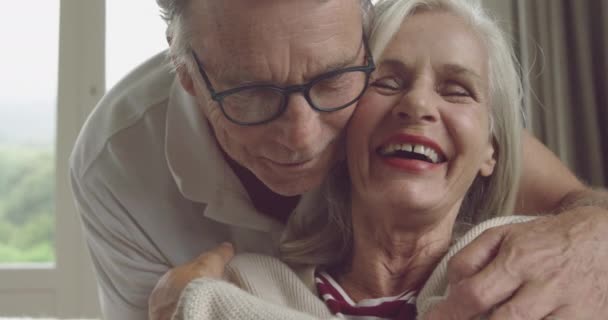 Front view close up of a senior Caucasian woman and man embracing and kissing - Materiał filmowy, wideo