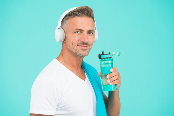 Gym aesthetics. Mature but still in good shape. Exercising in gym for better health. Healthy lifestyle. Man well groomed athlete with towel. Sportsman gym instructor with water bottle and headphones - Foto, Bild