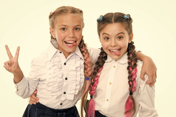 On same wave. Schoolgirls wear formal school uniform. Sisters little girls with braids ready for school. School fashion concept. Be bright. School friendship. Sisterhood relationship and soulmates - 写真・画像