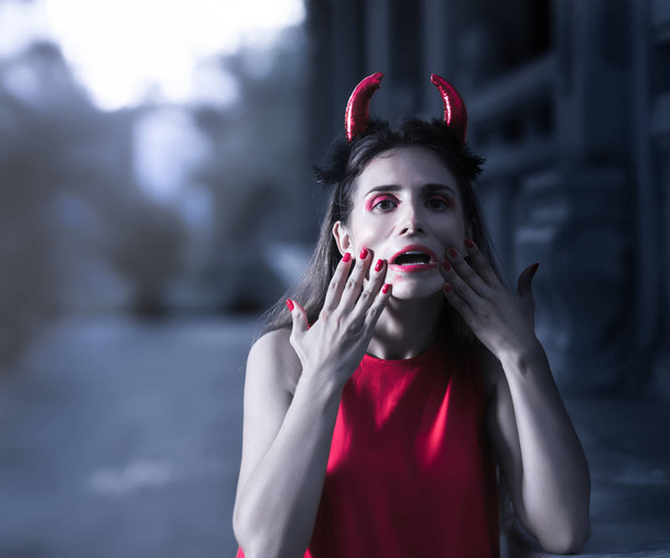 Beautiful woman in red dress and horns. Halloween - Fotografie, Obrázek