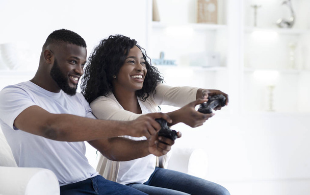 ビデオゲームでお互いに競争する遊び心のある黒いカップル - 写真・画像