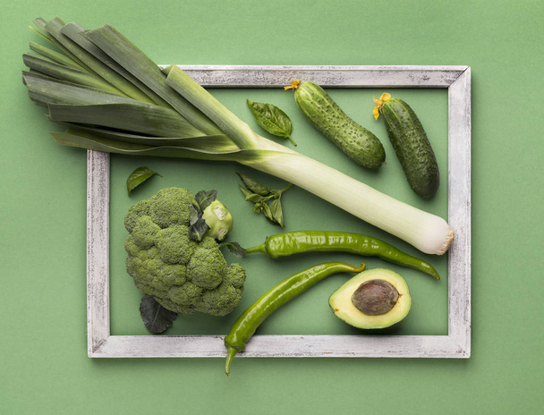 Green fresh vegetables inside wooden border on background - Foto, imagen