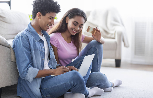 Teen couple shopping online with credit card and laptop - Photo, Image
