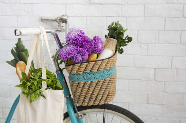 Fahrradkorb voller lila Blumen und frischem Gemüse im Freien - Foto, Bild