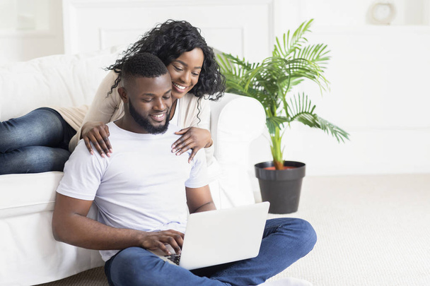 Wife embracing her husband who working as freelancer at home - Photo, Image