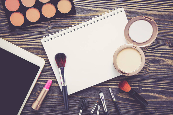 Top view a collection of cosmetic makeup and notebook on wooden  - Foto, Bild