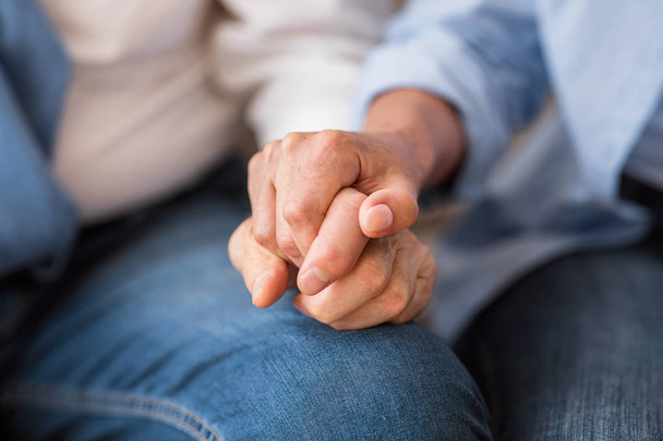 Love and support concept. Senior couple tenderly holding hands - Photo, Image