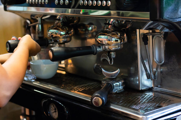 Kahveci kafede espresso makinesiyle kahve yapar.  - Fotoğraf, Görsel