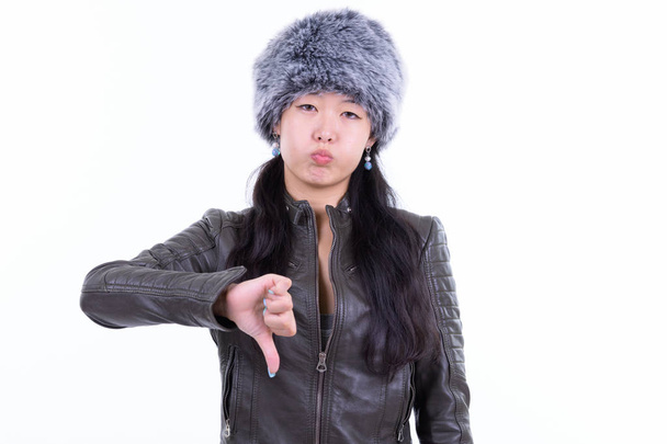 Muotokuva stressaantunut aasialainen nainen antaa peukalot alas talvella
 - Valokuva, kuva