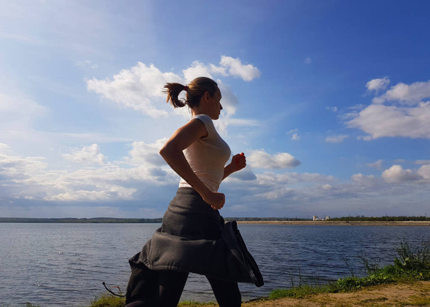 Vrouw joggen buiten in zomer Tine. Gezond Lyfestyle concept - Foto, afbeelding