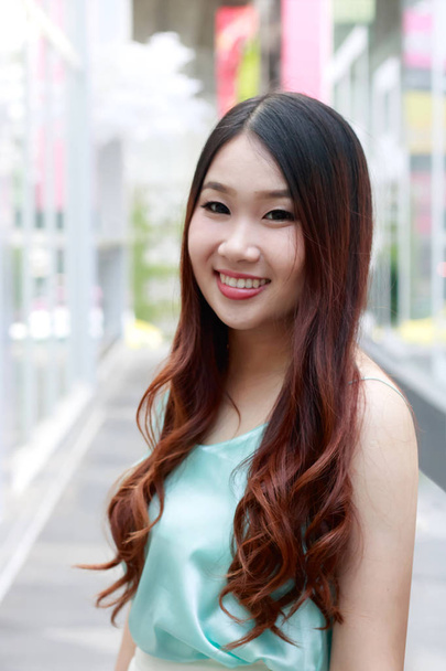 Kaunis aasialainen nainen hymyilee ulkona kohtaus
. - Valokuva, kuva
