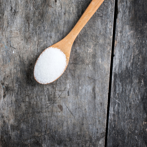 sugar in a wooden spoon - Фото, изображение