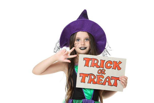 Beautiful girl in halloween costume holding paper with text Tric - Foto, Imagen