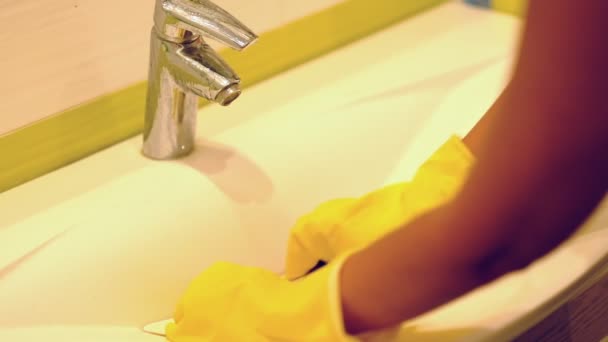 cámara lenta. Mujer haciendo tareas en el baño en casa, fregadero de limpieza y grifo con detergente en aerosol. Vista recortada
 - Metraje, vídeo