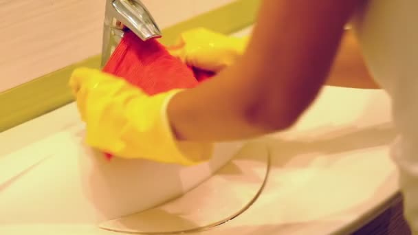 Zwolnionym. Kobieta robi prace w łazience w domu, umywalka i bateria z detergentem spray. Widok przycięty - Materiał filmowy, wideo