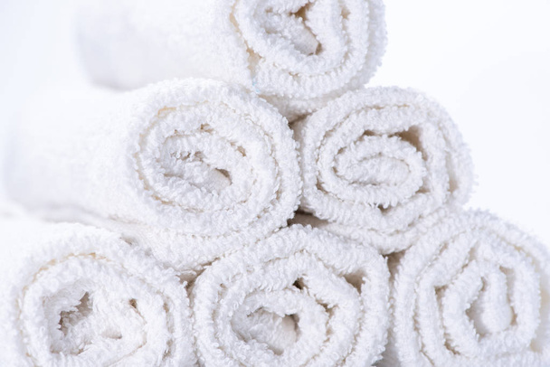 Toallas de rizo suavemente enrolladas para spa o masaje en un fondo blanco
 - Foto, Imagen