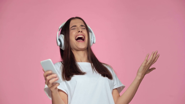 lány fülhallgató tánc és éneklés elszigetelt rózsaszín - Felvétel, videó