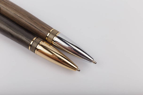 Two handmade ballpoint pens made of wood and metal on a white background. - Photo, Image