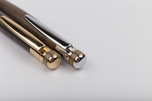Two handmade ballpoint pens made of wood and metal on a white background. - Фото, зображення