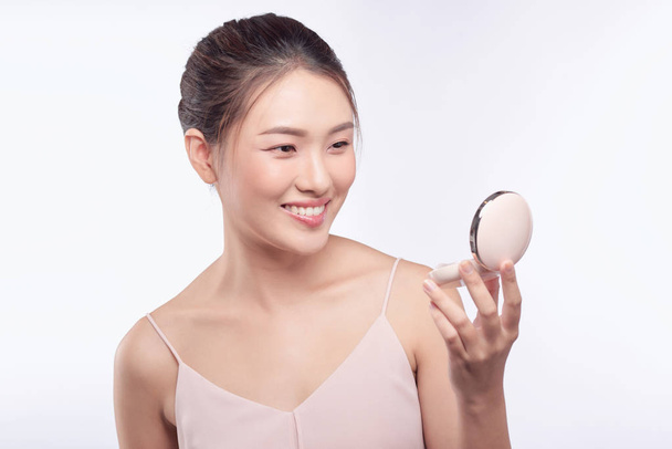 Belle femme asiatique appliquant la poudre bouffée à la joue maquillage de cosmétique, beauté de la fille avec sourire visage
 - Photo, image